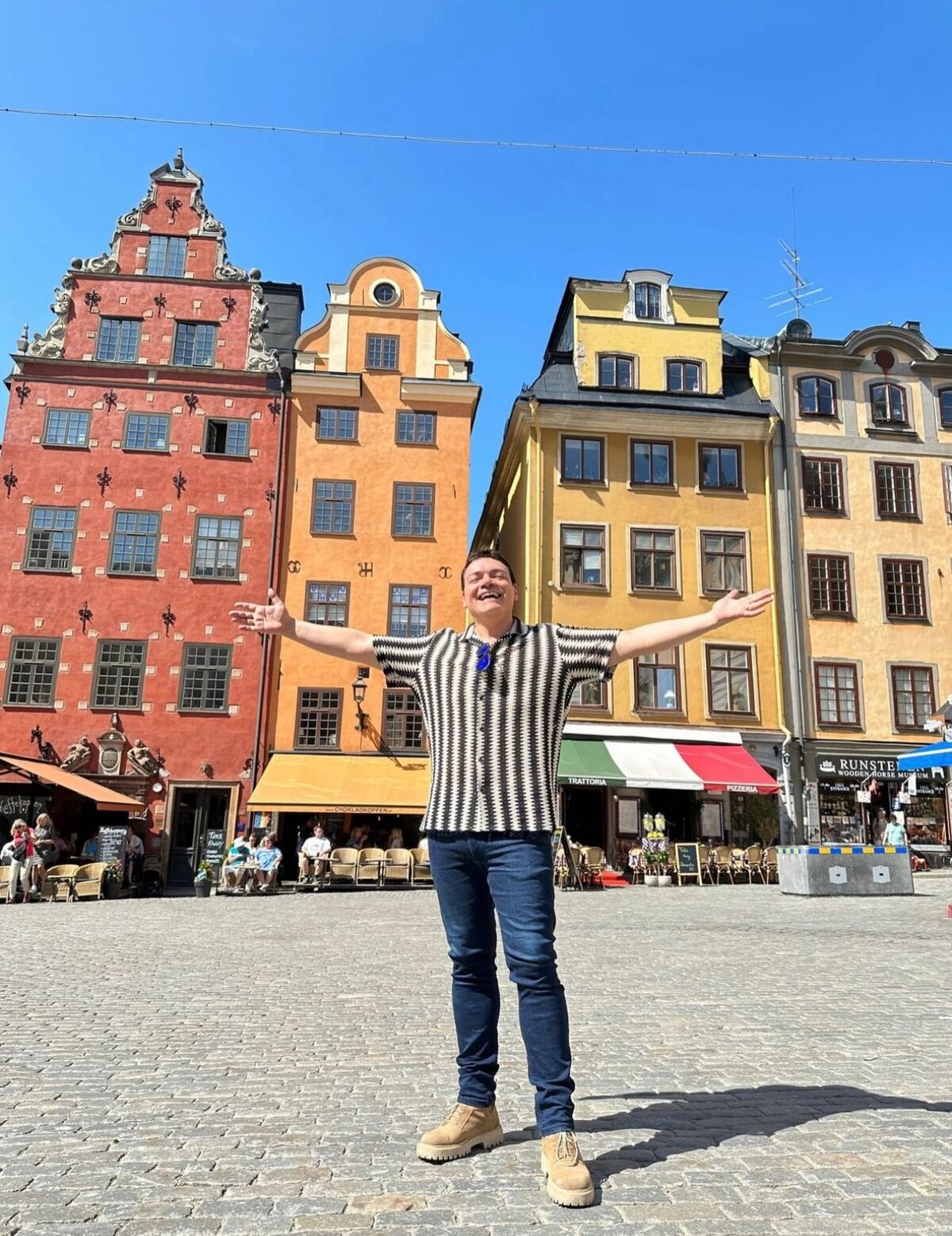 La piazza di Stortorget con le sue due piccole case (gialla e rossa), le più famose di Stoccolma. Immancabile la bandiera italiana di una trattoria-pizzeria